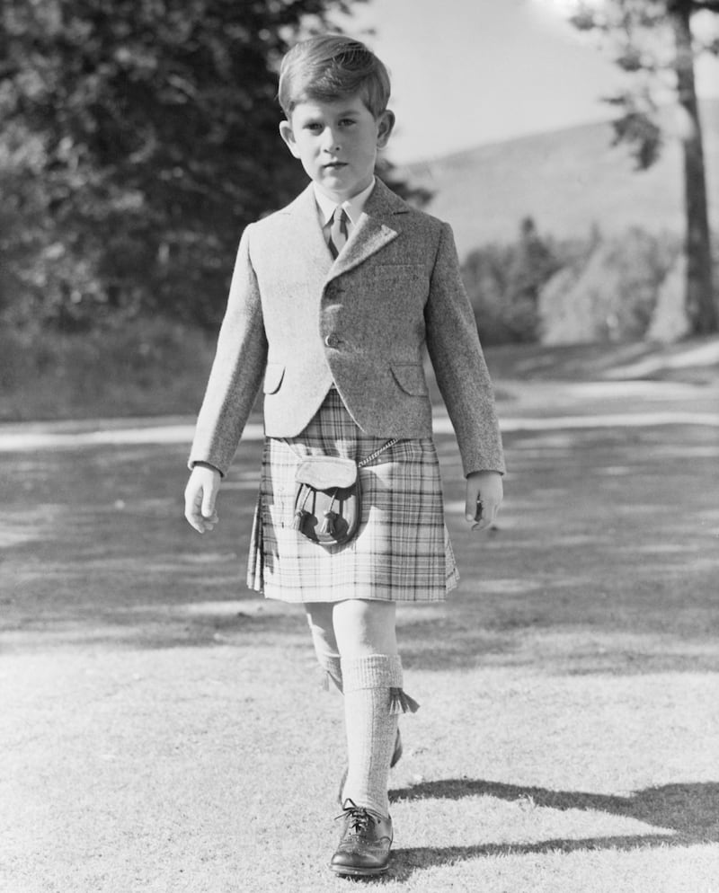 Resplendent in a kilt of Balmoral tartan, restricted to members of the royal family, Prince Charles poses for his 7th birthday portrait in the grounds of Balmoral Castle.