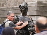 People pose for photographs with the iconic Molly Malone statue in Dublin's city centre after it was vandalised with black paint across it's front. The statue of the semi historical, semi-legendary figure is a popular tourist destination. Picture date: Wednesday August 16, 2023. (Photo by Brian Lawless/PA Images via Getty Images)