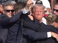 An injured Donald Trump waving his fist at his rally,