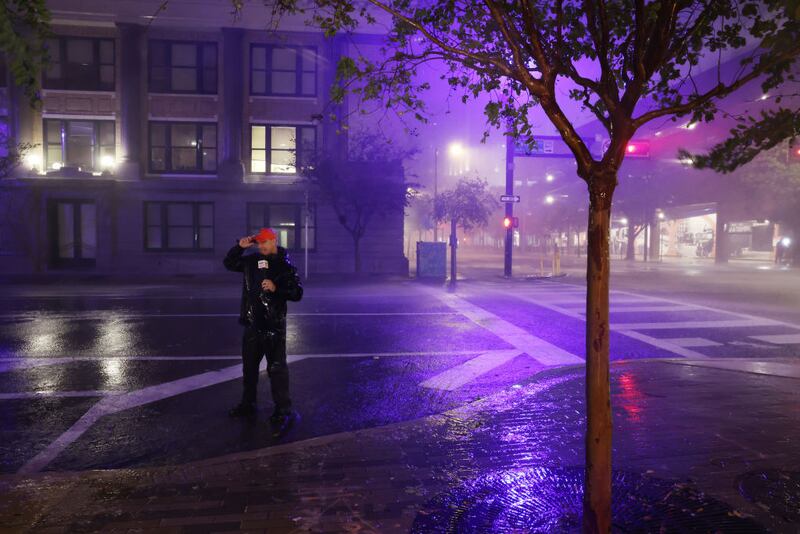 A television reporter stands on a downtown street as Hurricane Milton makes landfall on October 09, 2024, in Tampa, Florida.