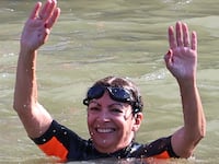 Paris Mayor Anne Hidalgo (R) swims in the Seine River, in Paris on July 17, 2024, to demonstrate that the river is clean enough to host the outdoor swimming events at the Paris Olympics.