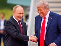 President Donald Trump (R) greets Russian President Vladimir Putin