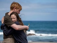 Andrea Riseborough and Domhnall Gleeson hug on the beach in a still from ‘Alice & Jack’