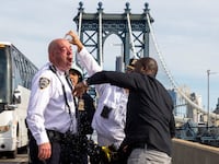 NYPD Assistant Chief James McCarthy is assisted after seemingly pepper spraying himself while police arrested pro-Palestinian demonstrators blocking traffic on the Manhattan Bridge in New York City.