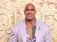 Dwayne Johnson wears a purple suit jacket, purple shirt, and black pants at the 82nd Annual Golden Globe Awards at the Beverly Hilton on January 5, 2025.