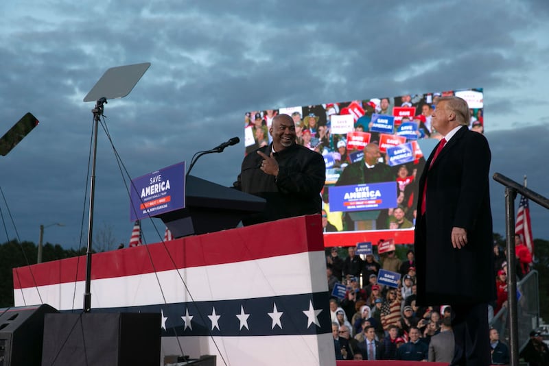 Donald Trump and Mark Robinson stand together on stage at a campaign rally.