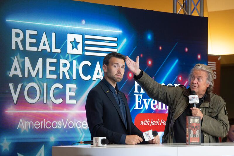 Conservative political activist and host of Human Events Jack Posobiec, center, and former Trump adviser Steve Bannon broadcast live during Turning Point USA's AmericaFest at the Phoenix Convention Center on December 20, 2024 in Phoenix, Arizona.