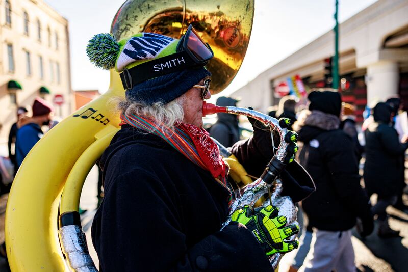 A protester performs on the street as they march through frigid conditions, with temperatures near 10 degrees Fahrenheit (minus 12 Celsius), in a neighborhood in Minneapolis, Minnesota, on December 20, 2025, where many Somali, Latino and Hispanic immigrants live and work, during the "MN Love Our Immigrant Neighbors - ICE Out of MN!" rally calling for the removal of US Immigration and Customs Enforcement from Minnesota. (Photo by Kerem YUCEL / AFP via Getty Images)