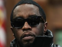 Sean Combs, wearing sunglasses, sits in a courtroom.