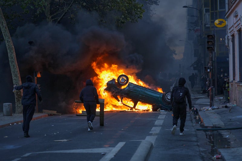 PARIS, FRANCE - OCTOBER 17: Rioters set cars on fire at the Canal Saint Martin during severe unrest on October 17, 2026 in Paris, France. The involvement of the Gilets Jaunes (Yellow Vests) with the ongoing French school blockades expands the scope of these demonstrations by linking localised student grievances to broader economic policies. Student unions originally initiated the movement to protest underfunding, deteriorating infrastructure, and acute teacher shortages across French high schools and universities. By joining the protests, the Gilets Jaunes introduce their established platform against austerity cuts, rising living costs, and surging fuel prices into the youth-led action. (Photo by Remon Haazen/Getty Images)