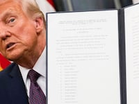 Donald Trump holding up an executive order.