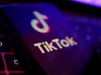 An illustration of the TikTok logo on a phone atop a laptop keyboard
