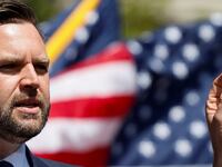 J.D. Vance speaks at event with American flags in the background.