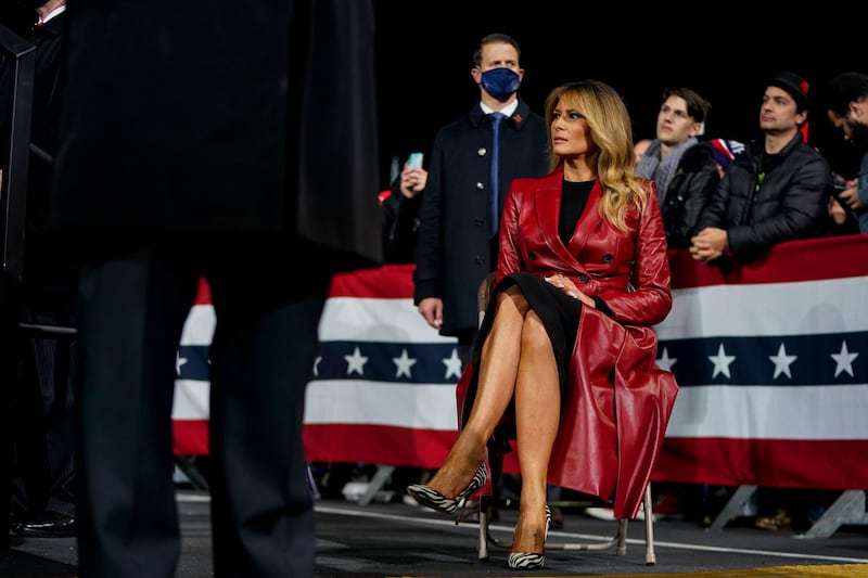 Melania Trump sits in a chair at a rally.