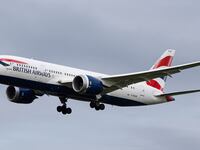 British Airways Boeing 787-8 Dreamliner aircraft spotted flying on final approach over the roofs of the houses of Myrtle avenue for landing at London Heathrow Airport LHR in the UK.