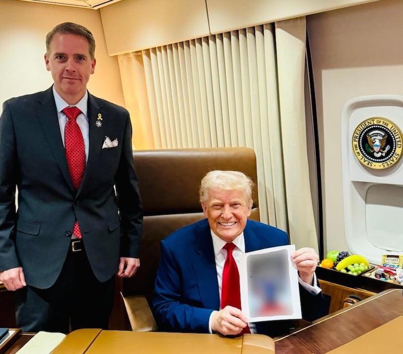 Scott Jennings smirks while standing next to a smiling President Donald Trump on Air Force One. The 47-year-old CNN pundit posted the photo to X on Friday in what appears to be a teaser for a U.S. Senate run.