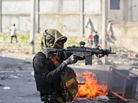 A policeman points a gun at protesters during a demonstration calling for the resignation of Prime Minister Ariel Henry in Port-au-Prince last month.