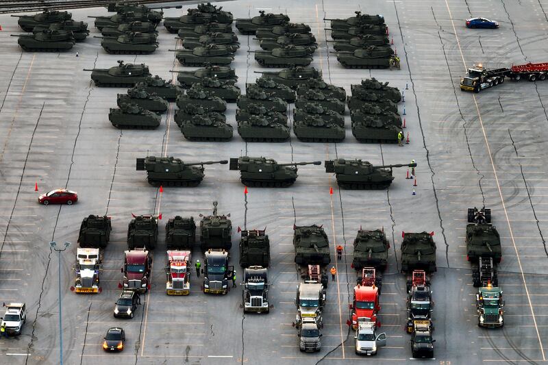 U.S. Army vehicles for Trump's military parade, including M1 Abrams tanks, are loaded onto trucks in a Maryland rail yard.
