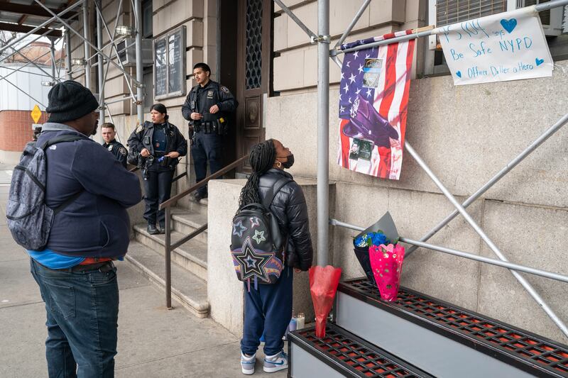 New Yorkers pay their respects at a memorial for slain NYPD officer Jonathan Diller outside the 101st Precinct.