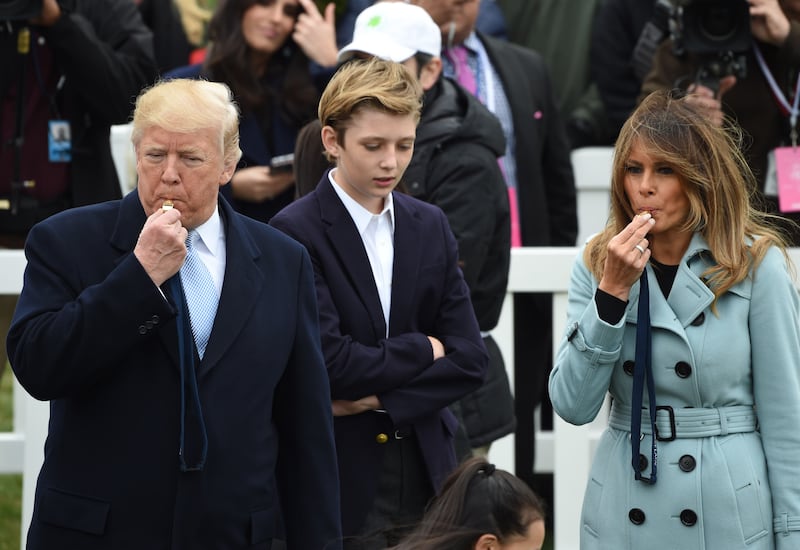 President Donald Trump and First Lady Melania Trump, with son Barron, blow whistles at the start of an Easter egg roll during Easter celebrations at the White House in 2018.