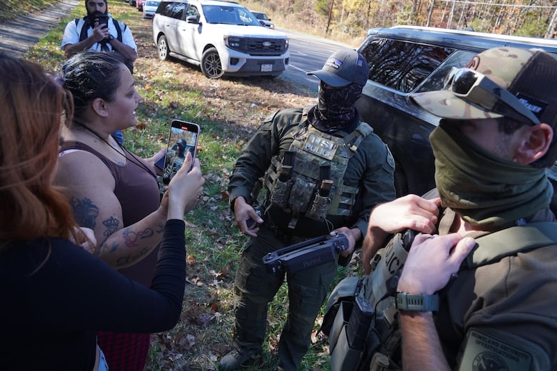 Department of Homeland Security Investigations officers search for two individuals who fled the scene after being stopped while selling flowers on the side of the road on November 16, 2025