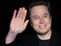 Elon Musk holds a stuffed toy