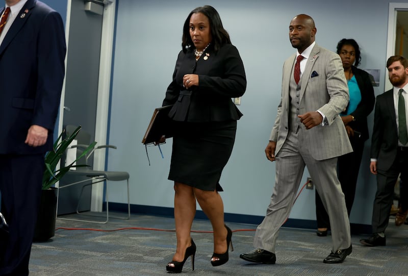 Fulton County District Attorney Fani Willis, trailed by special prosecutor Nathan Wade, arrives at a news conference in August.
