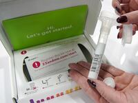 A company representative show off what is in a DNA kit at the 23andMe booth at the RootsTech annual genealogical event in Salt Lake City, Utah,