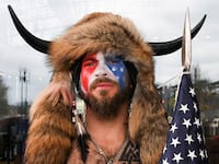 Jacob Chansley, wearing a buffalo headdress with his face painted, poses for a photo on the day of the Jan. 6 insurrection in 2021.