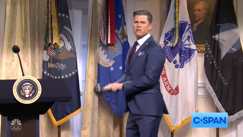 SNL, Colin Jost as Pete Hegseth lifting a kettlebell.