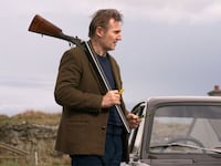 Liam Neeson holds a gun in a still from 'In the Land of Saints and Sinners'