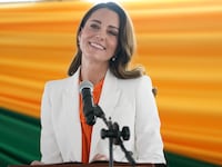 Kate Middleton smiles while giving remarks at a podium.