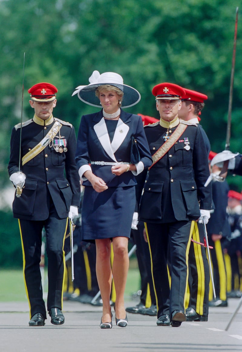 Diana, Princess of Wales, wore the sharp Catherine Walker skirt suit while presenting new colors to the Light Dragoon Guards Regiment in Bergen-Hohne, Germany, on July 22 1995.