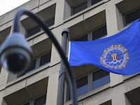 A photo of FBI headquarters and a bureau flag flying out front.