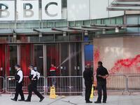 Police officers walk outside the BBC building, near where a march for a protest in solidarity with Palestinians, covered in red paint.