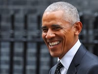 Barack Obama smiles in a suit as he visits London.