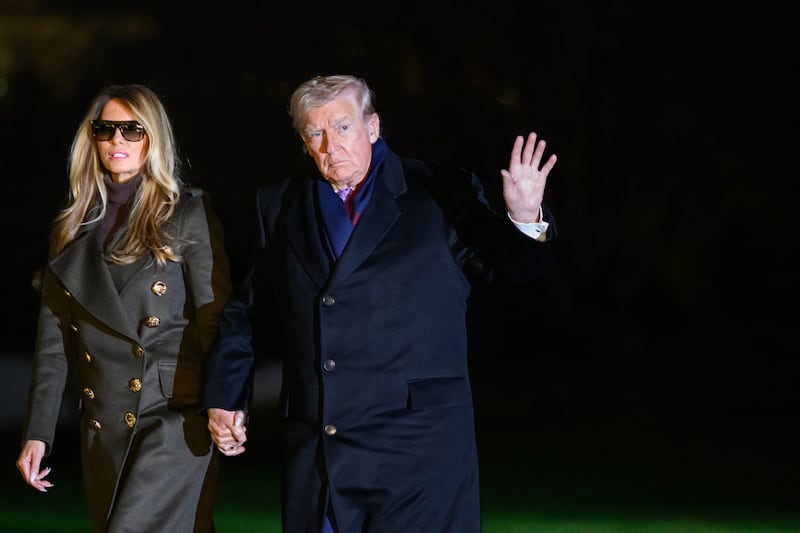 US President Donald Trump, accompanied by First Lady Melania Trump, waves to reporters after landing on the South Lawn upon arrival at the White House in Washington, DC, on November 30, 2025. Trump returned to Washington after spending the Thanksgiving holiday at his Palm Beach, Florida resort. (Photo by Mandel NGAN / AFP via Getty Images)