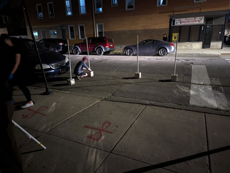 Two members of the People's CDOT work to set up the traffic calming installation at a crosswalk in Chicago's South Side.