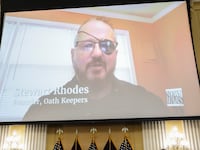 Steward Rhodes appears in a video played on a big screen during a probe into the Jan. 6 Capitol insurrection.