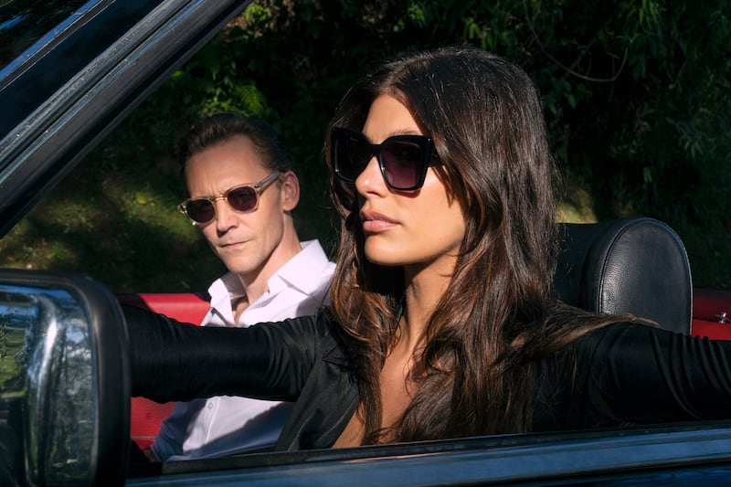 Tom Hiddleston as Jonathan Pine and Camila Morrone as Roxana