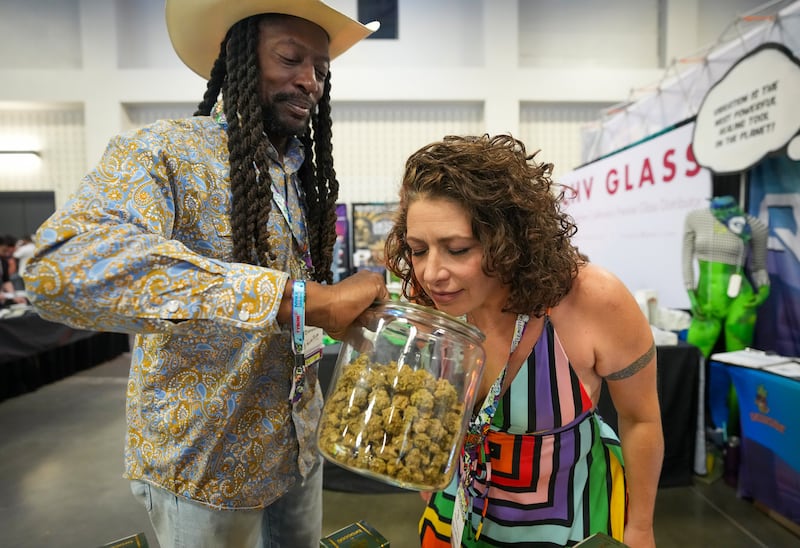 AUSTIN, TEXAS - SEPTEMBER 11: Cara Todkill smells cannabis flower from Warren Campbell, owner of W Squared Distribution in Houston, at CHAMPS Trade Show at the Palmer Events Center Thursday, Sept. 11, 2025. The three-day business-to-business trade show focuses on the counterculture, smoke shop, and cannabis-related industries.