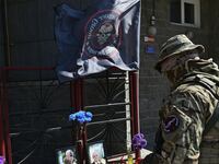 A Wagner fighter stands in front of a makeshift memorial with portraits of mercenary chief Yevgeny Prigozhin and Wagner group commander Dmitry Utkin outside the local Wagner office in Novosibirsk, Russia, Aug. 24, 2023.