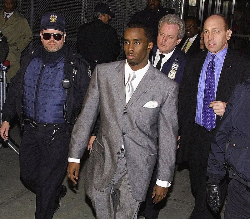 Surrounded by police officers, rapper Sean "Puffy" Combs leaves State Supreme Court in New York City 15 March, 2001.