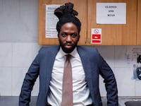 A still from 'Dreaming Whilst Black' that shows Adjani Salmon in a suit