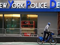 A cyclist rides past a New York Police Department (NYPD) station in Times Square