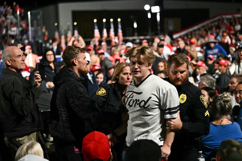 Security officers escort out a protestor as US President Donald Trump speaks at a midterm campaign rally at Pitt-Greenville Airport in Greenville, North Carolina, on October 20, 2026. (Photo by Kent NISHIMURA / AFP via Getty Images)