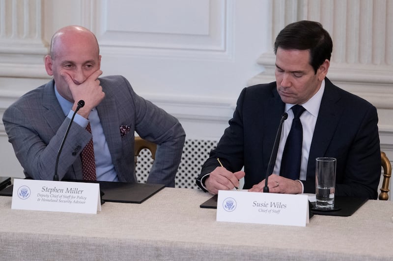 US Secretary of State Marco Rubio (R) writes a note to US President Donald Trump saying a Middle East peace deal is "very close" during an event at the White House in Washington, DC, on October 8, 2025, as White House Deputy Chief of Staff Stephen Miller (L) looks on.