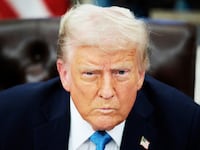 Donald Trump talks to reporters after signing an executive order.