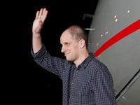 Evan Gershkovich waves on the tarmac after returning home after more than a year in lock-up