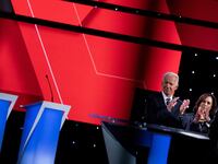 Kamala Harris and Joe Biden clap as other candidates take the stage ahead of the second round of the second Democratic primary debate during the 2020 presidential campaign season on July 31, 2019.